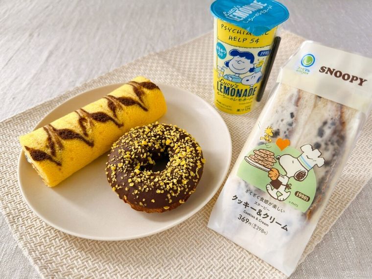 スヌーピーのクッキークリームサンドやスヌーピーのチョコケーキドーナツなどが皿に盛り付けられている様子