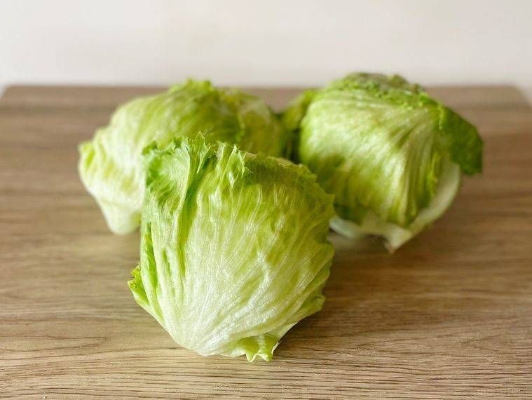 木の机にあるレタス3つ