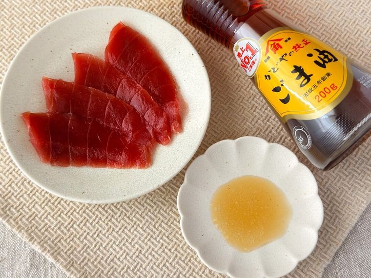 テーブルの上にまぐろや金印純正ごま油、塩が並んでいる様子