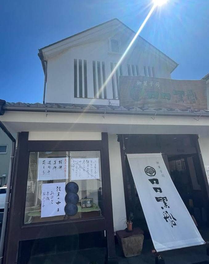 二階建ての建物に木の看板や白い店頭幕が張られたロロ黒船の外観