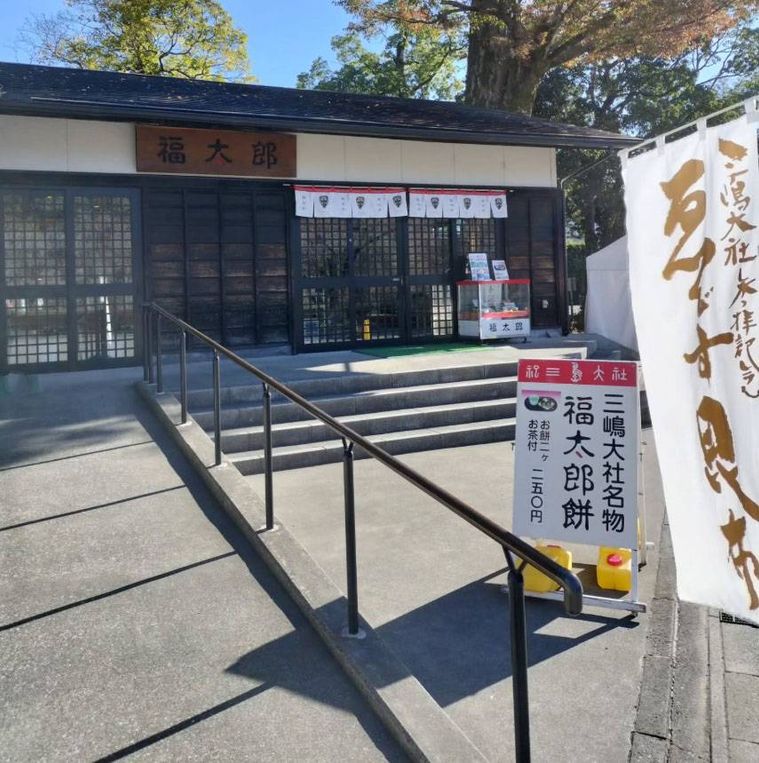 入り口に階段とスロープ、格子状の扉がある福太郎本舗の外観