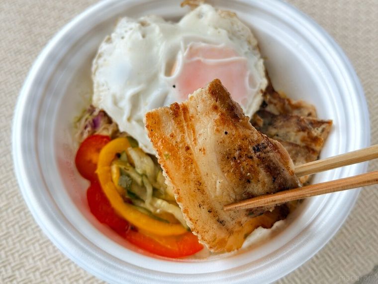 コムタム風ポークライスのポークを箸で持っている様子