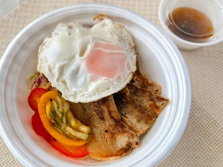 ご飯の上に具材を盛り付けたコムタム風ポークライスが置かれている様子