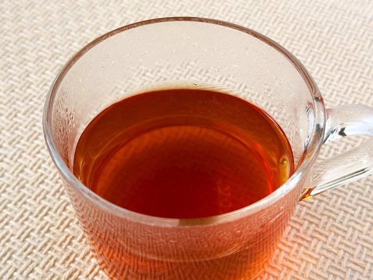 コップに入った淹れたてのはちみつチャイティーバッグが置かれている様子