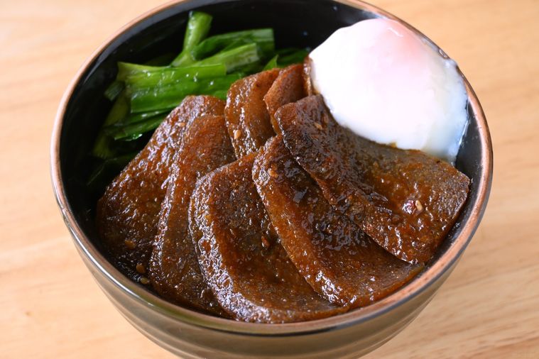 黒い丼にごはんと焼肉のたれを絡めて焼いたこんにゃくとニラ、温泉卵が盛り付けられている