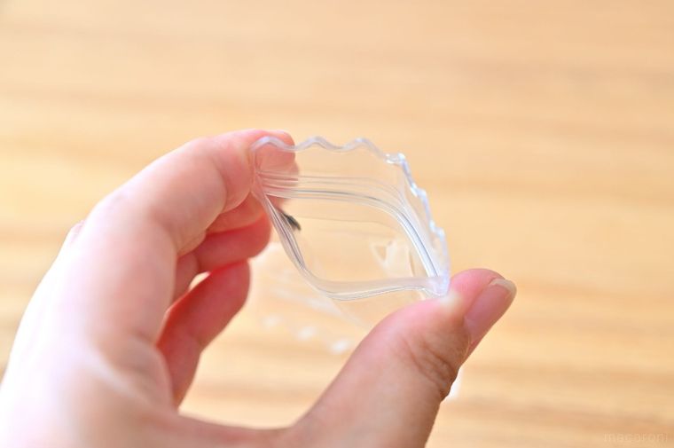 透明の袋を手で開けている