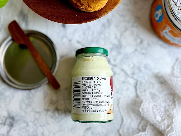 コストコのクロテッドクリームの瓶に貼ってある商品ラベル、バターナイフがのったシルバーのトレイ