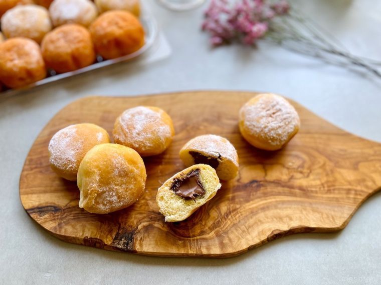 ウッドボードの上に5個取り分けて半分にカットしたコストコのベニエココアヘーゼル