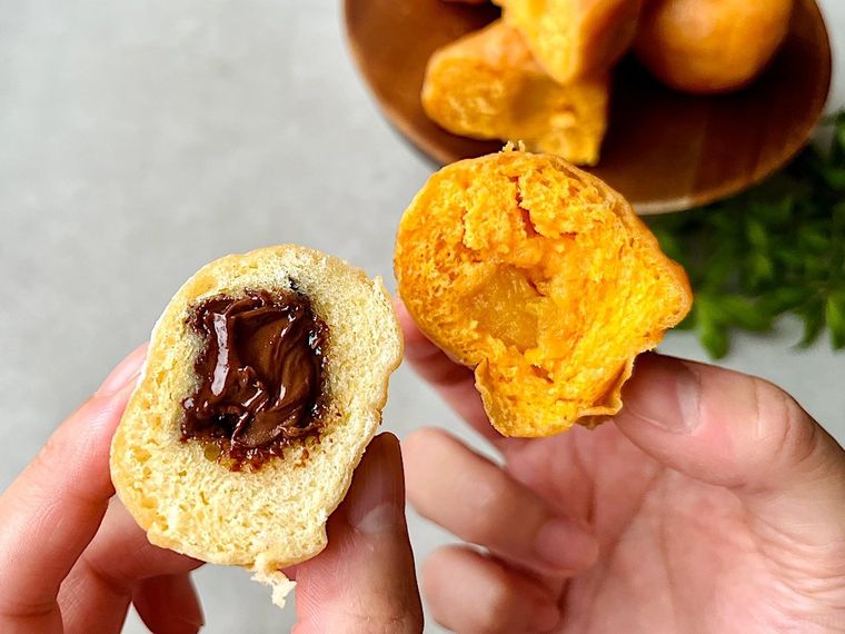 半分にカットして断面が見えるように指で持ち上げたコストコベニエパッションフルーツとココアヘーゼル