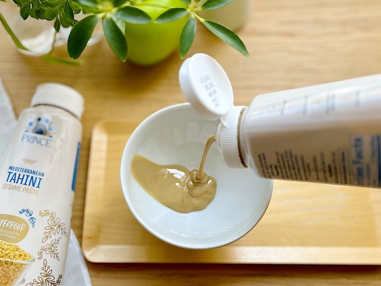コストコのタヒニゴマペーストをボトルから白い小皿へ注ぎ入れているところ