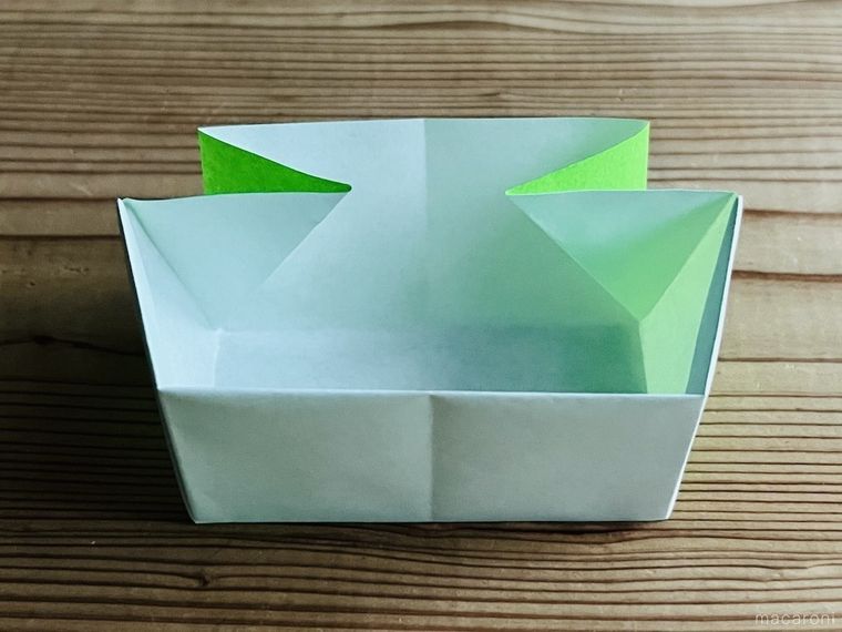 緑色の折り紙でつながる箱を作っている様子