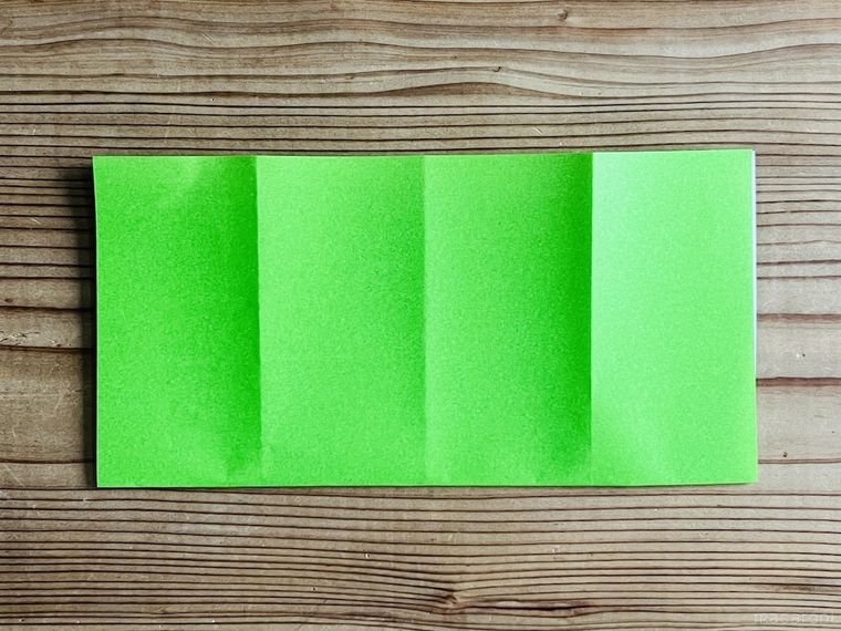 緑色の折り紙を半分に折った様子