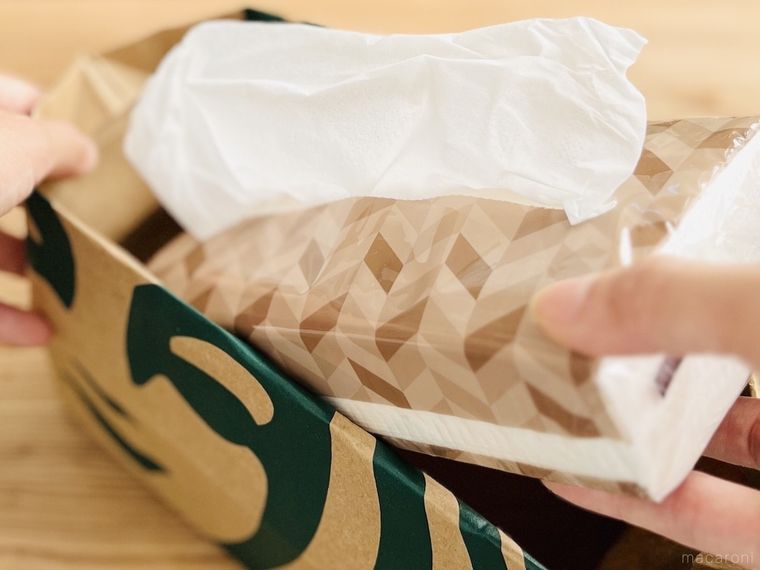 スターバックスの紙袋にソフトパックのティッシュを入れようとしている様子