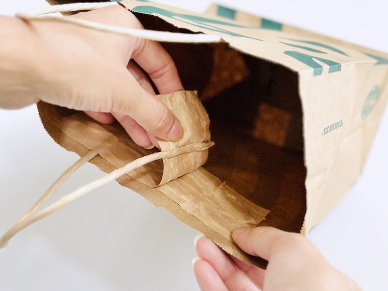 スターバックスの紙袋の持ち手を剥がしている様子