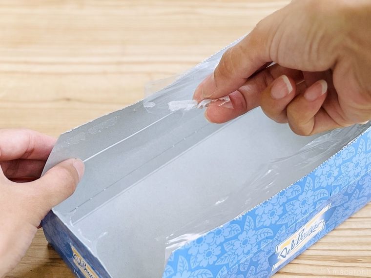 ティッシュ箱のフィルムを取っている様子