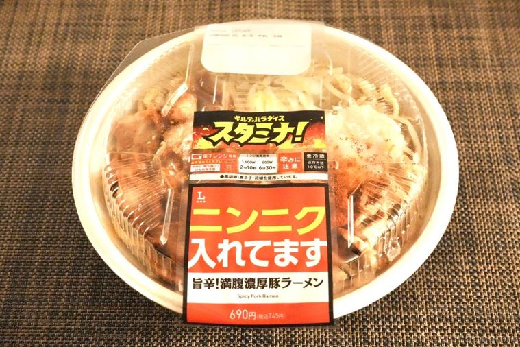茶色いランチョンマットとコンビニの旨辛二郎系ラーメンが盛られた白い容器