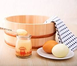 風呂桶や手ぬぐいと卵のそばに置かれた湯もみプリン
