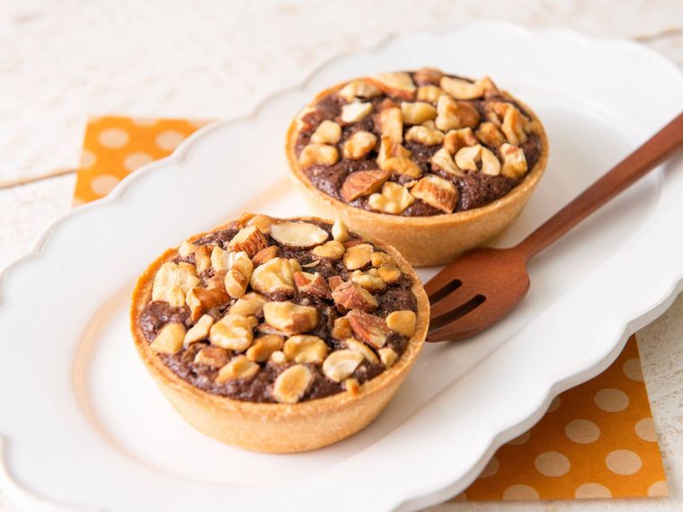 お皿にのせられた、木の実がたっぷり乗ったタルト