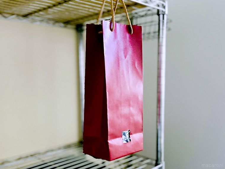 側面に穴が開いたワイン袋をキッチンに吊り下げた様子