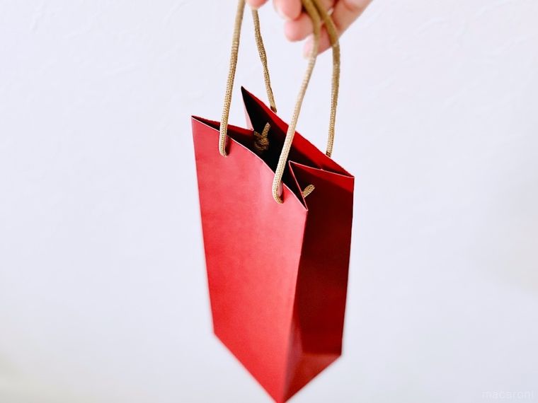 赤いワイン袋を手で持っている様子