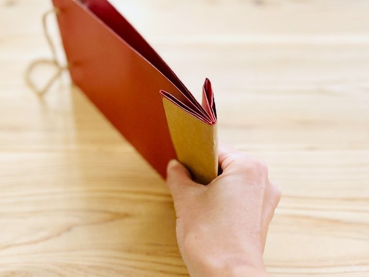 赤いワイン袋の底を半分に折っている様子