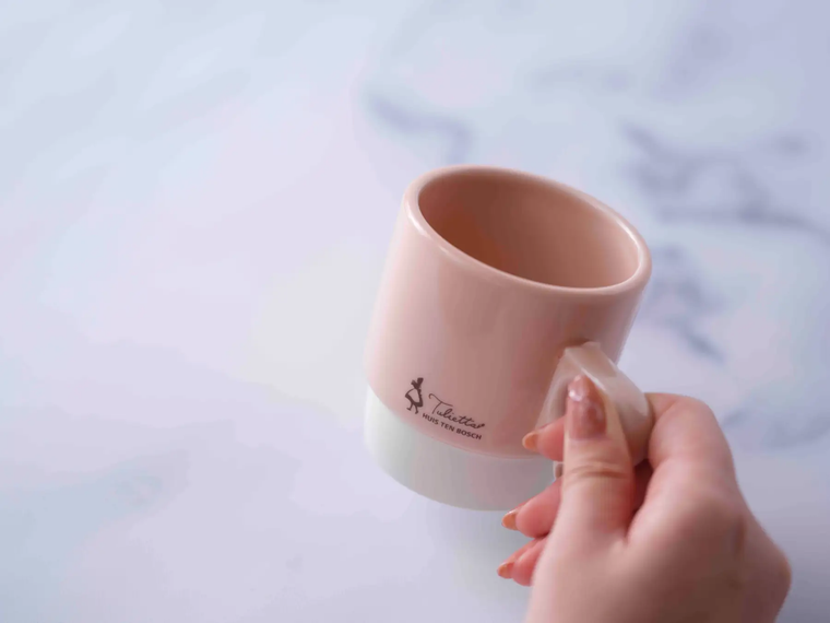 ピンクのマグカップを手にしている様子