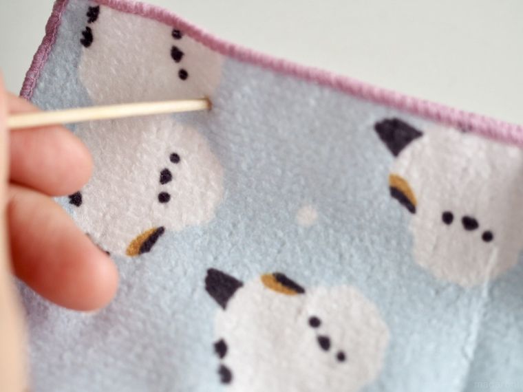 ミニタオルに穴をあけているところ