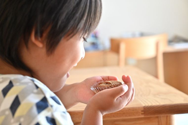 両手にお菓子を持って笑顔の男の子