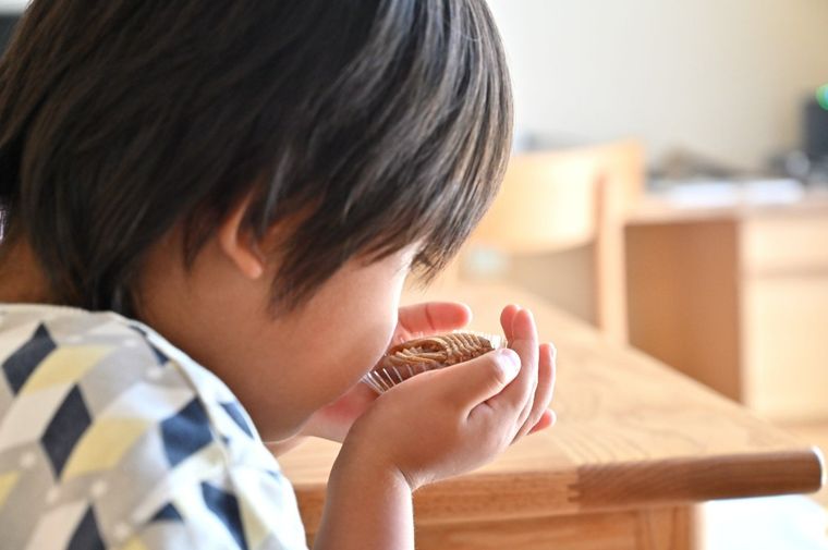 男の子がお菓子のにおいをかいでいる