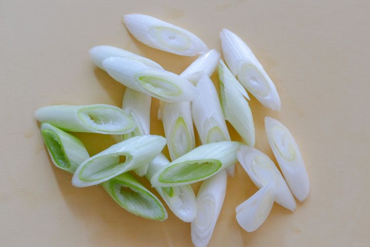 斜め切りの長ねぎが並ぶまな板