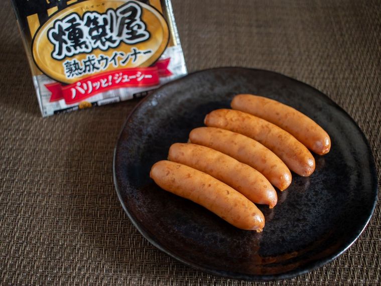 燻製屋のパッケージと黒いお皿に並んだウインナー