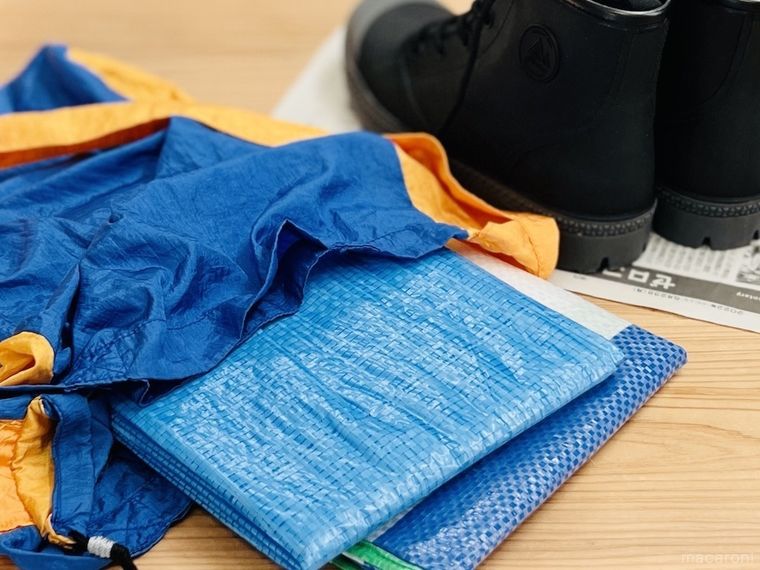 レジャーシートが入った青いエコバッグと黒い靴