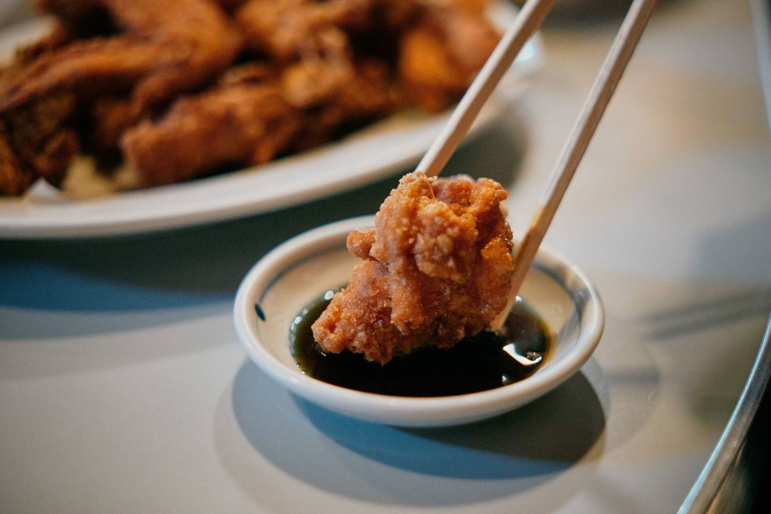 鳥松のザンギをたれに付けている様子