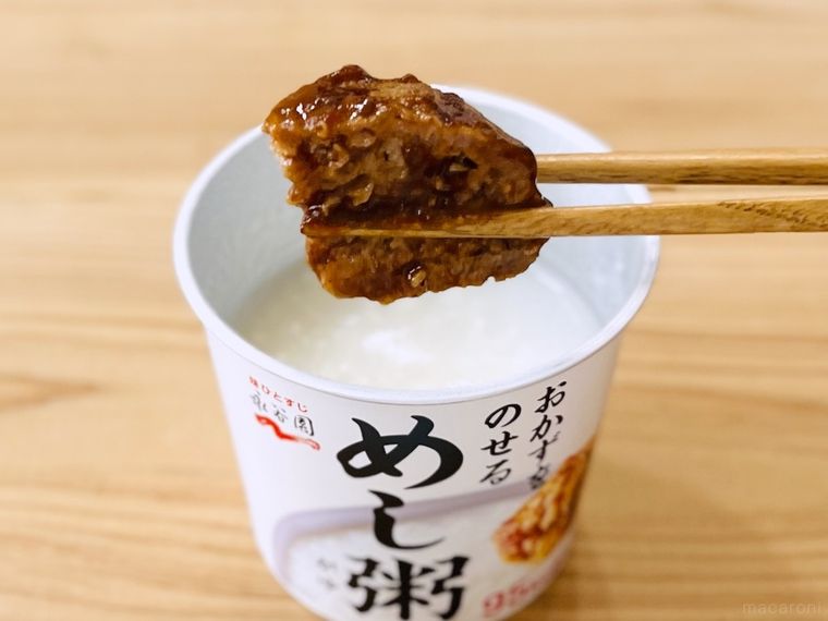 めし粥にハンバーグをのせようとしている様子