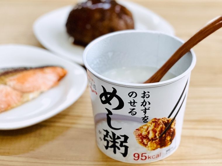 食卓にめし粥、焼き鮭、ハンバーグが並んでいる