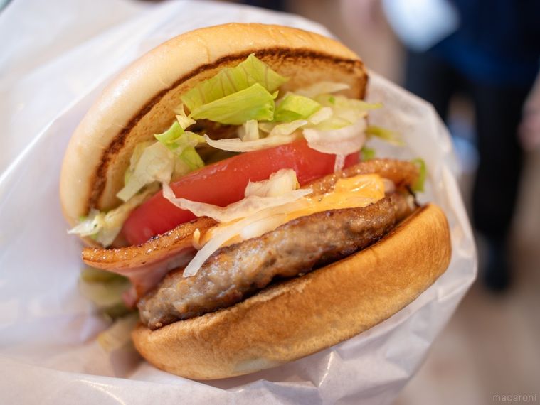 モスバーガー黒アヒージョ ベーコンバーガーを手に持っている様子