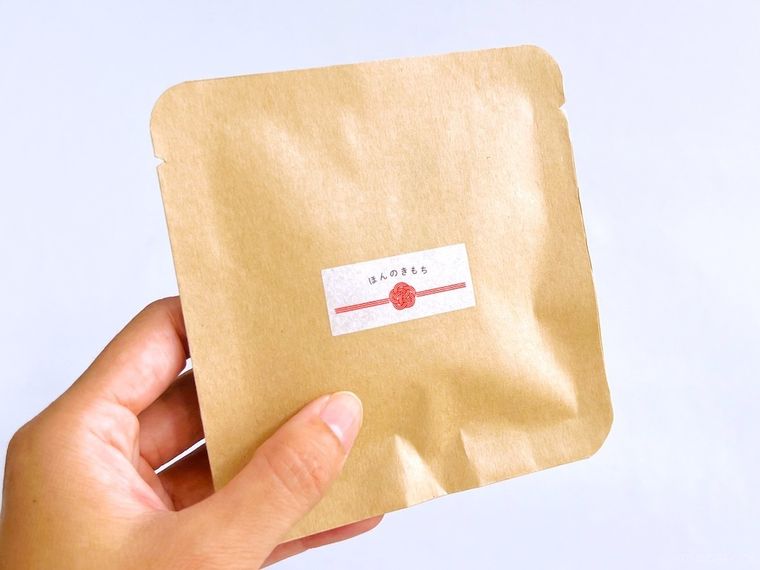 茶封筒でラッピングしたプチギフトを手で持っている様子