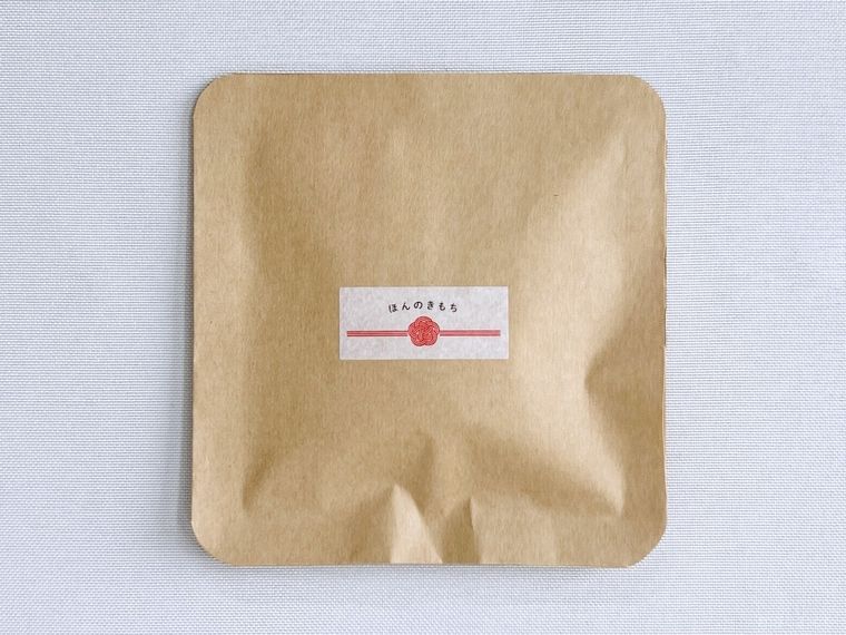 ティーバッグが入った茶封筒にシールを貼った様子