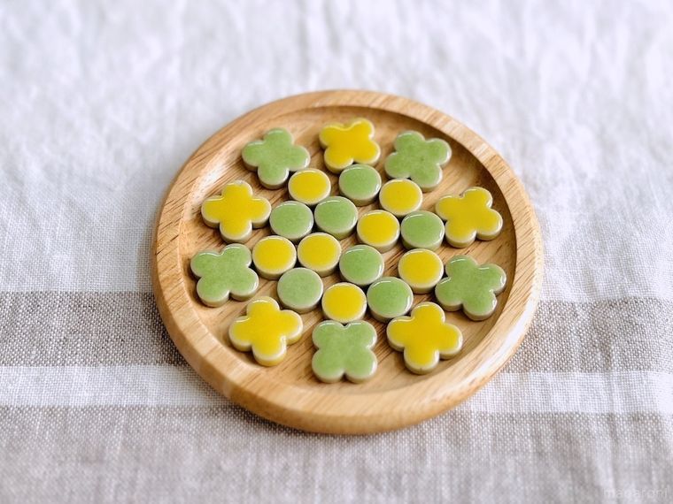 木のコースターに黄色と緑色のタイルを並べた様子