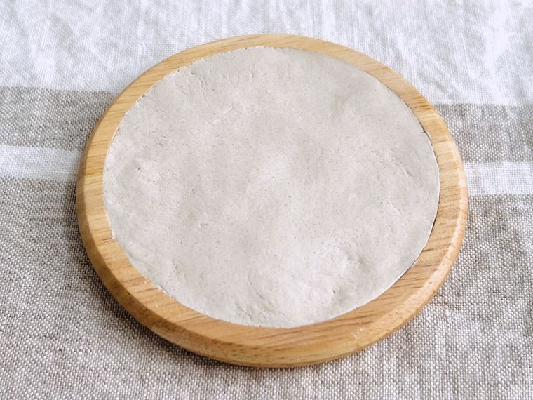 木のコースターに石粉ねんどを敷き詰めた様子