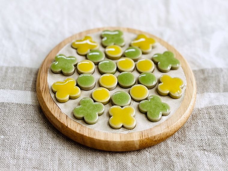 石粉ねんどを敷き詰めたコースターに黄色と緑色のタイルを並べた様子