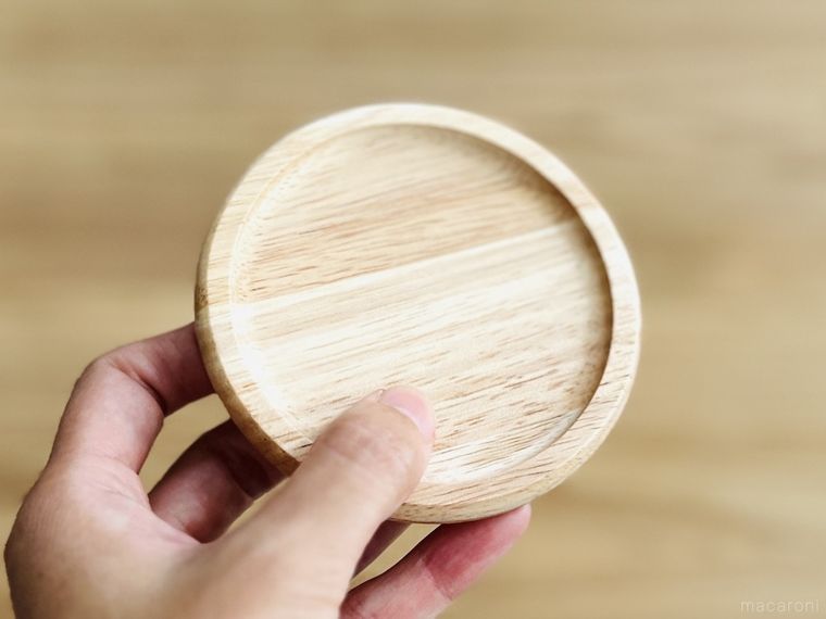 木のコースターを手で持っている様子