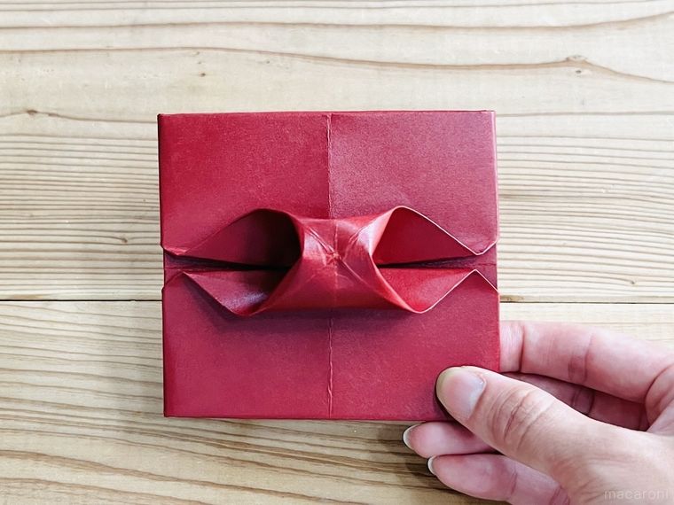 赤い紙で写真立てを作っている様子