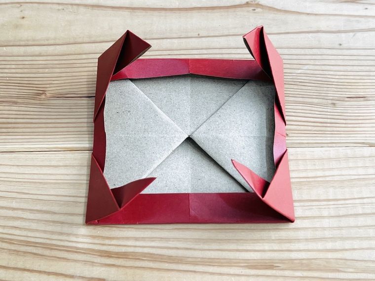 赤い紙で写真立てを作っている様子