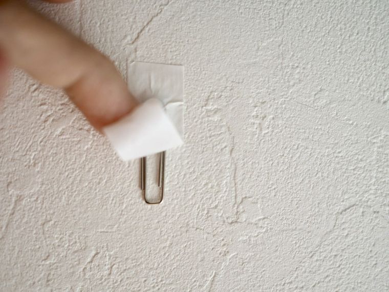 壁にクリップを貼るところ