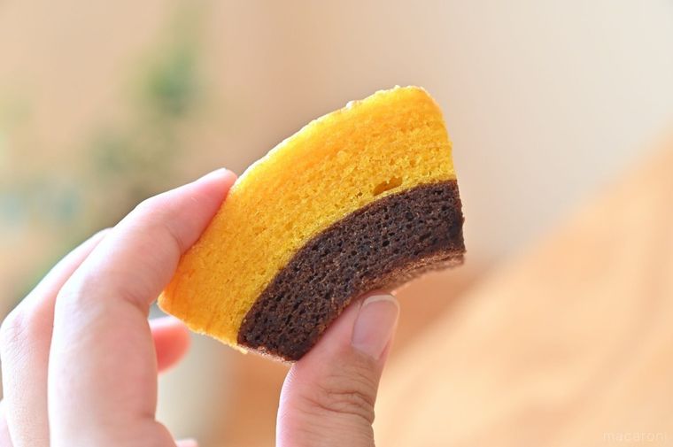 2層仕立てのバウムクーヘンを手に持っている