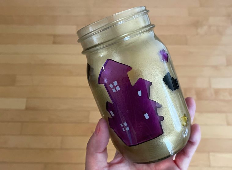 ゴールドのスプレーを吹きかけた瓶を手に持っているところ