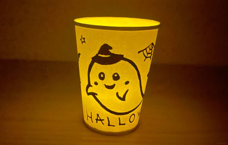 手描きの紙コップランタンに灯りをともした写真