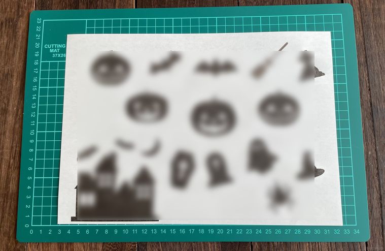 ハロウィンのイラストをプリントアウトした紙とカッターマット