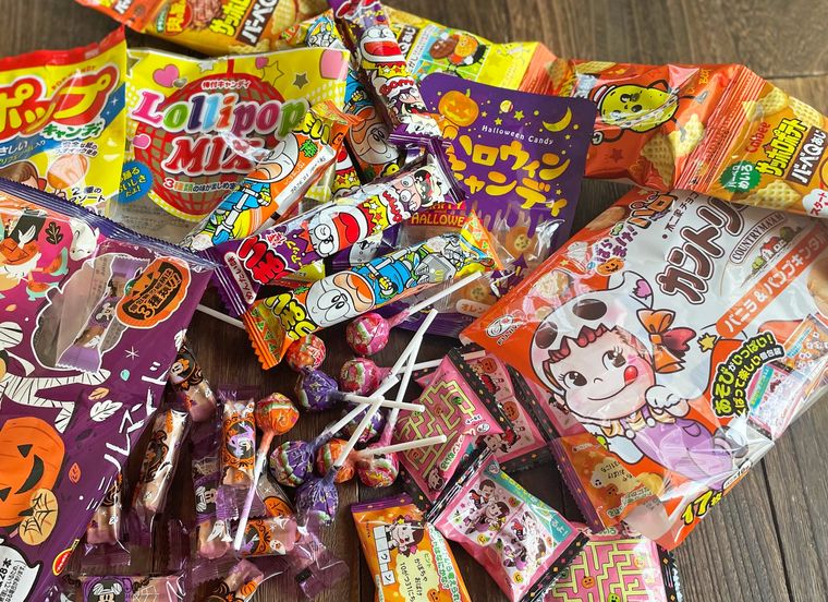 テーブルにハロウィンバージョンのお菓子を敷き詰めた写真